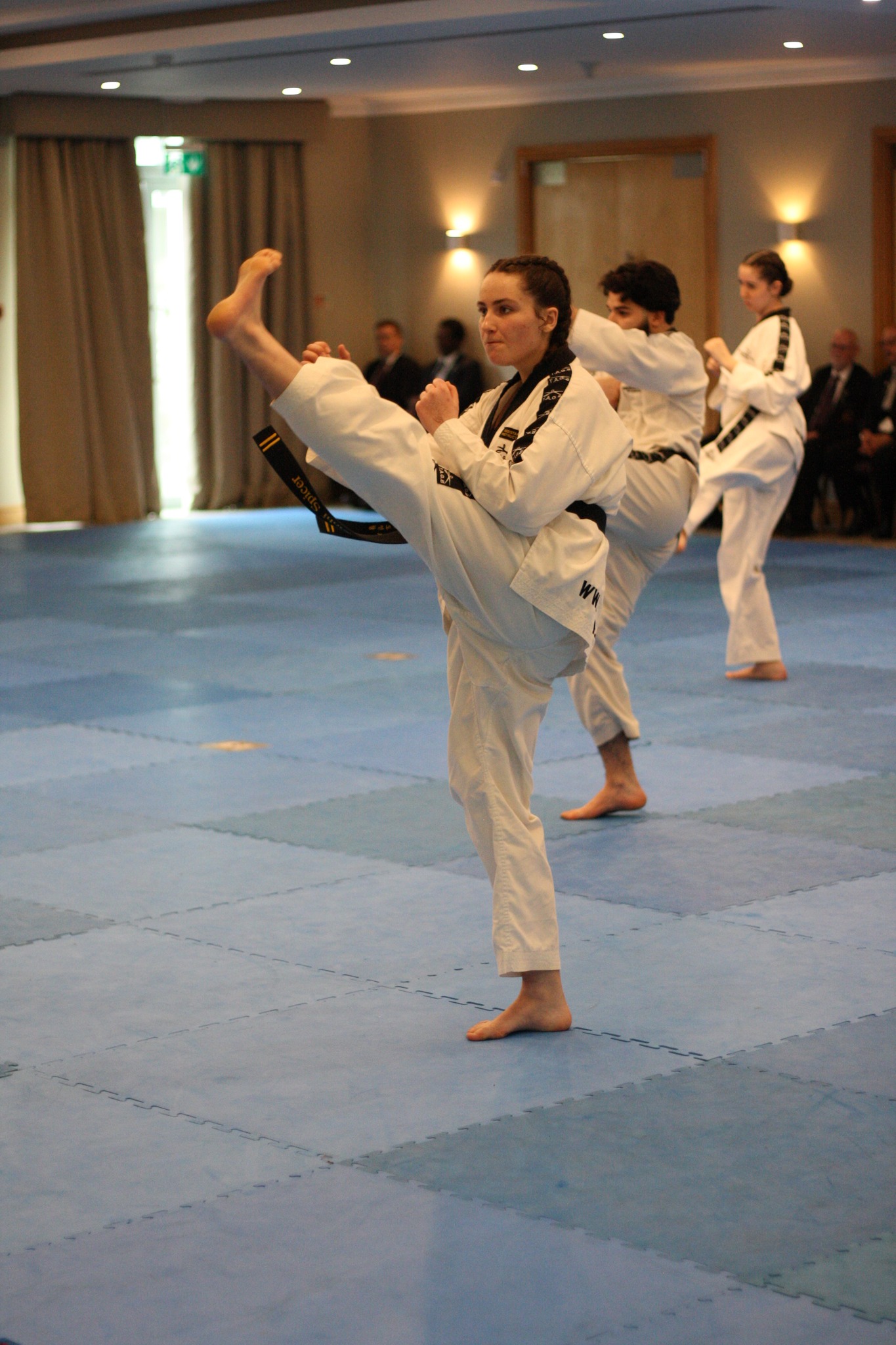 Female Corsham Tae Kwon Do black belt performing a high kick during class